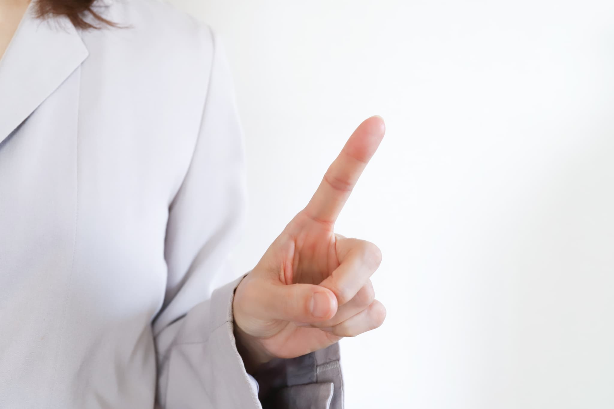 指さしで注意点を確認する女性の手元