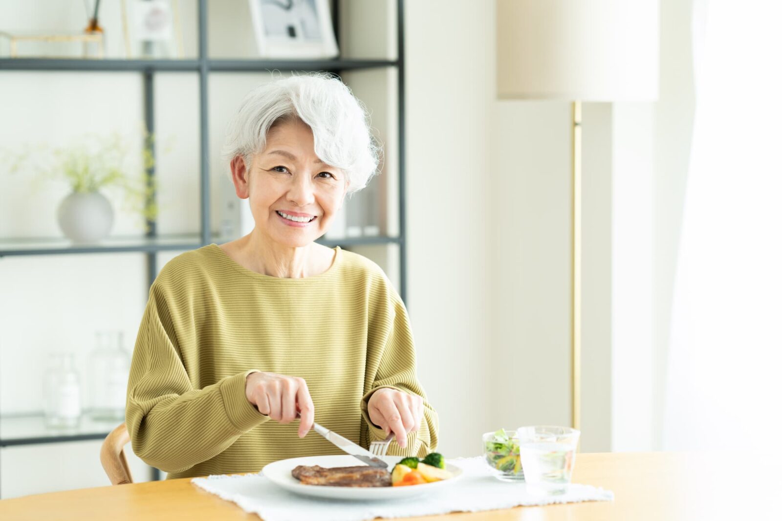 奥歯をインプラントにして快適に食事をする女性