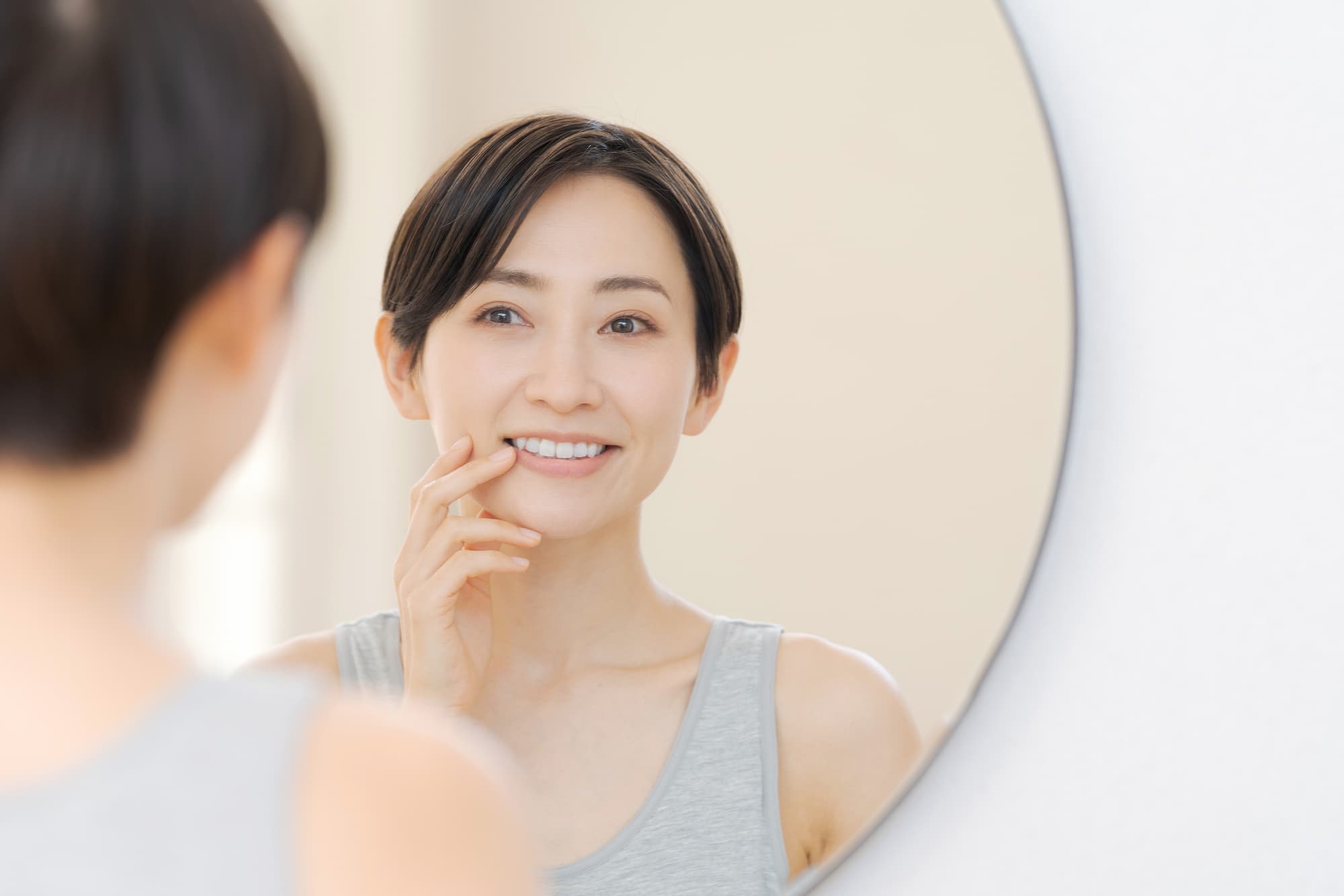 前歯を鏡で確認する女性