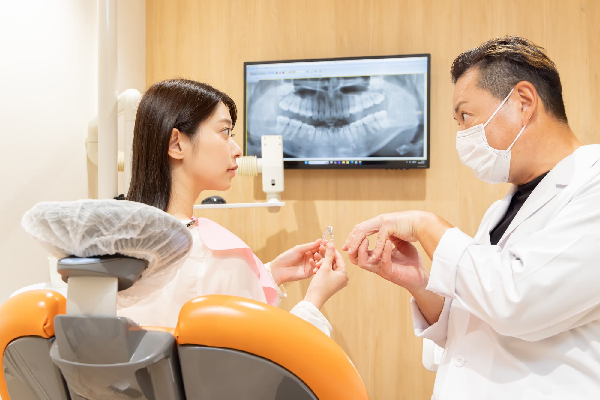 インビザラインの治療について歯科医からカウンセリングを受ける患者