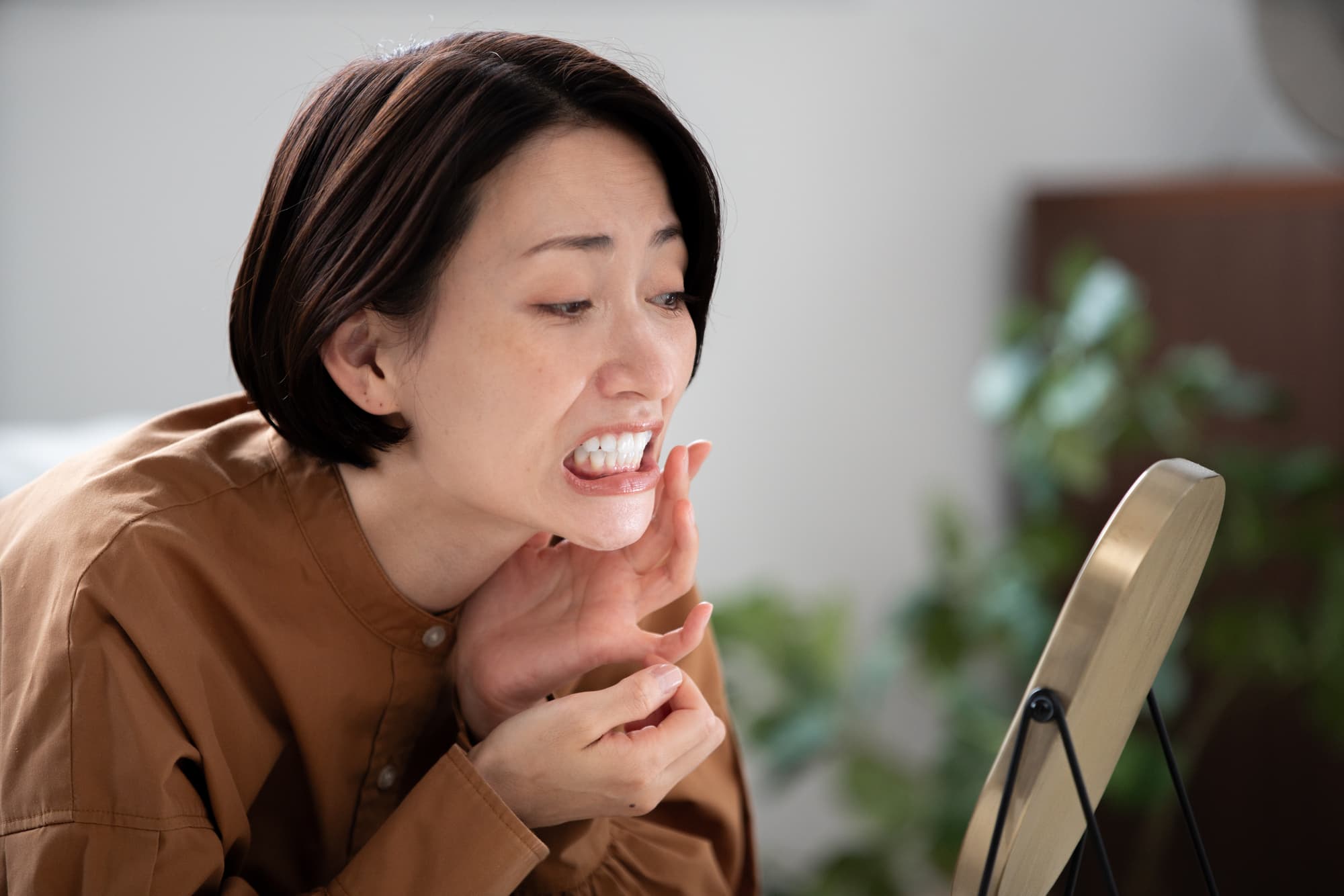 鏡で歯茎を確認する女性