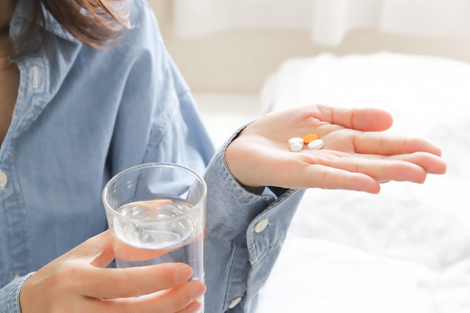 矯正治療中に痛みがある人が鎮痛剤を飲むイメージ