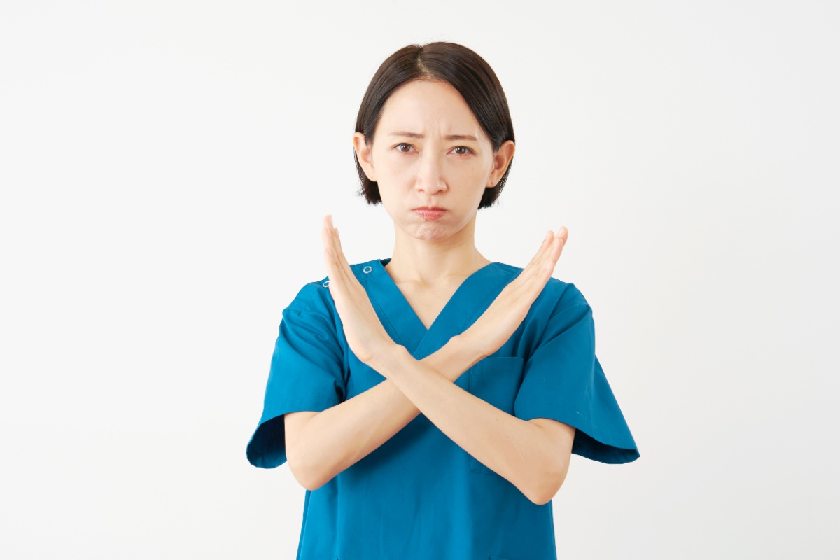 両手でバツをする歯科医