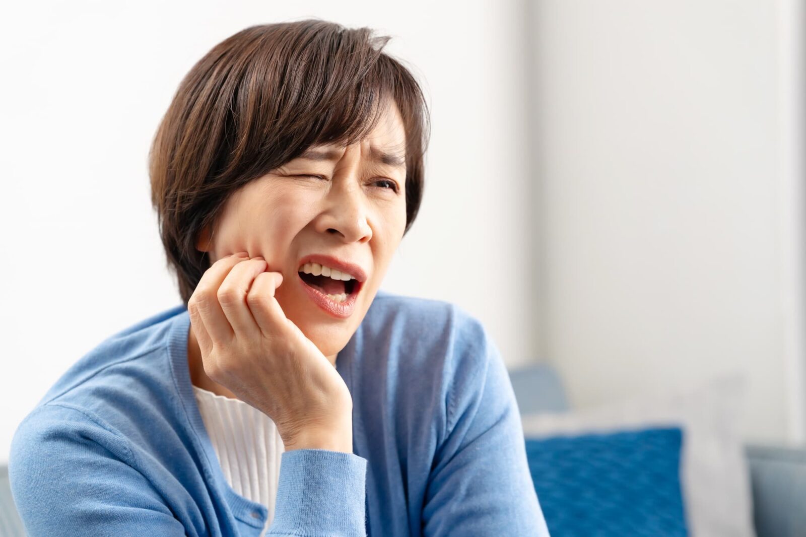 奥歯の虫歯を放置して痛みが増した女性