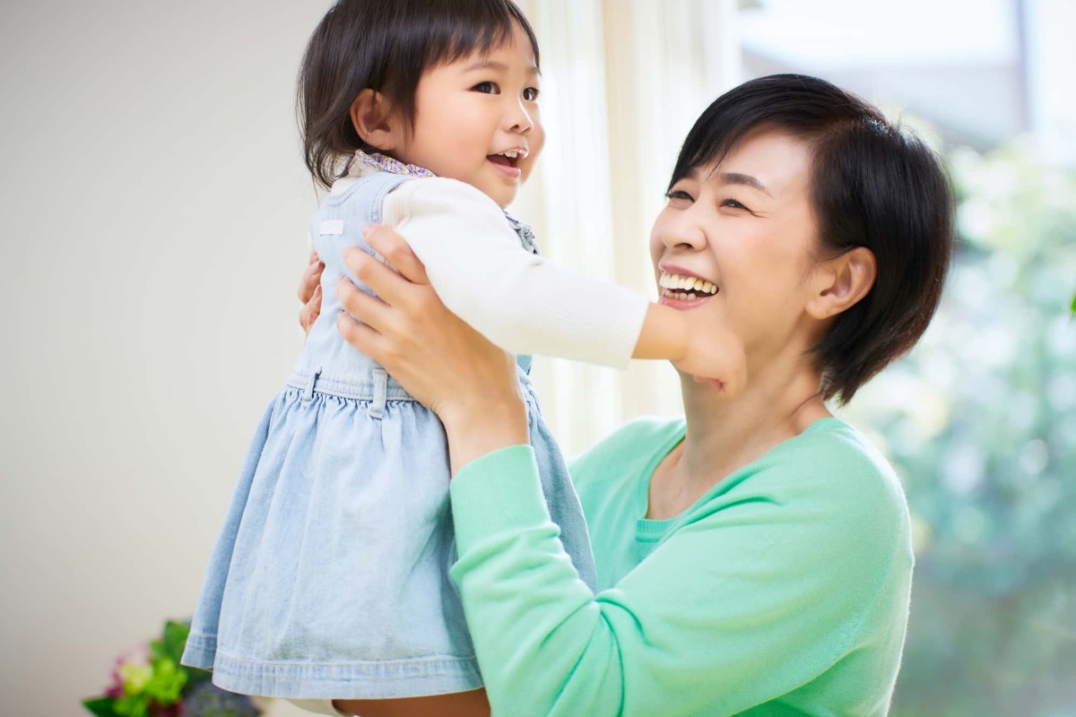 孫を高い高いする笑顔の女性
