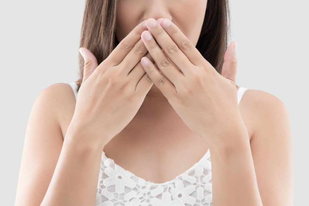 マウスピース矯正中に口臭が出て手で口をおさえる女性